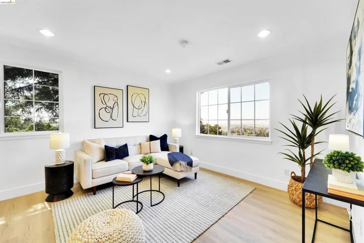 Bright living space featuring light wood-finish flooring, recessed lighting, and white baseboards