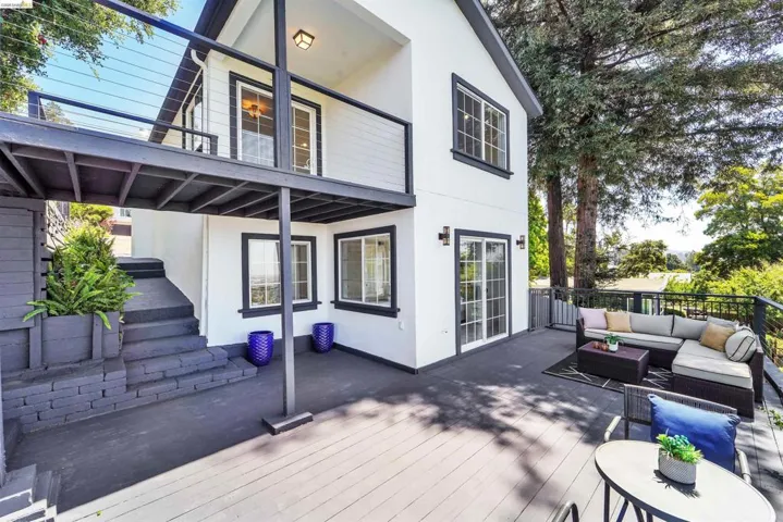 Multi-level outdoor living space featuring an expansive deck and a second-story balcony with cable railings