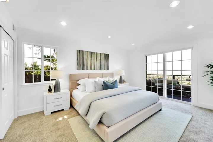 Bedroom featuring sliding glass doors with grid detailing, recessed lighting, and a white trim window