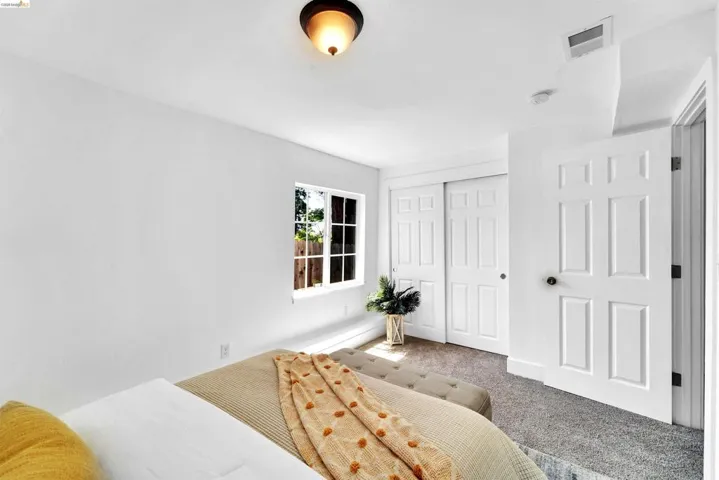 Interior room featuring a white paneled door, a white window frame with multiple panes, and a flush mount light fixture