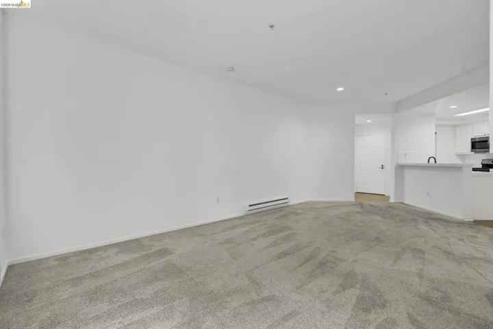 Spacious room featuring light gray carpet flooring and white painted walls