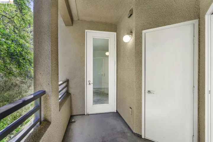 Private balcony featuring textured stucco walls and concrete flooring