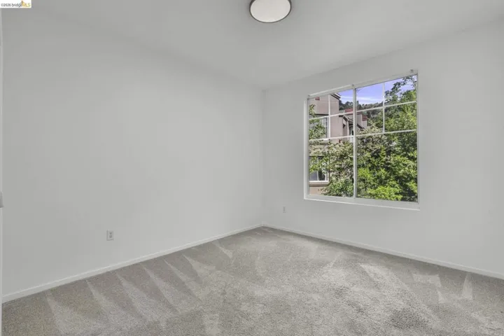 Neutral-toned carpet flooring and white painted walls characterize this bright interior space