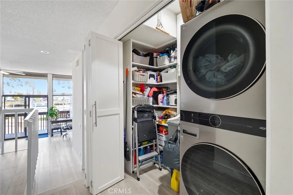 In unit hidden laundry closet with custom storage and a laundry sink