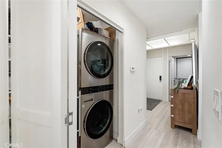 In unit hidden laundry closet with custom storage and a laundry sink