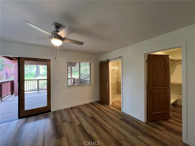 Primary bedroom showing private deck access, ensuite bath and walk in closet