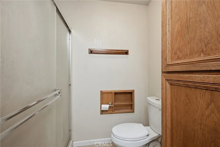 Water closet in primary bathroom has stand alone shower.