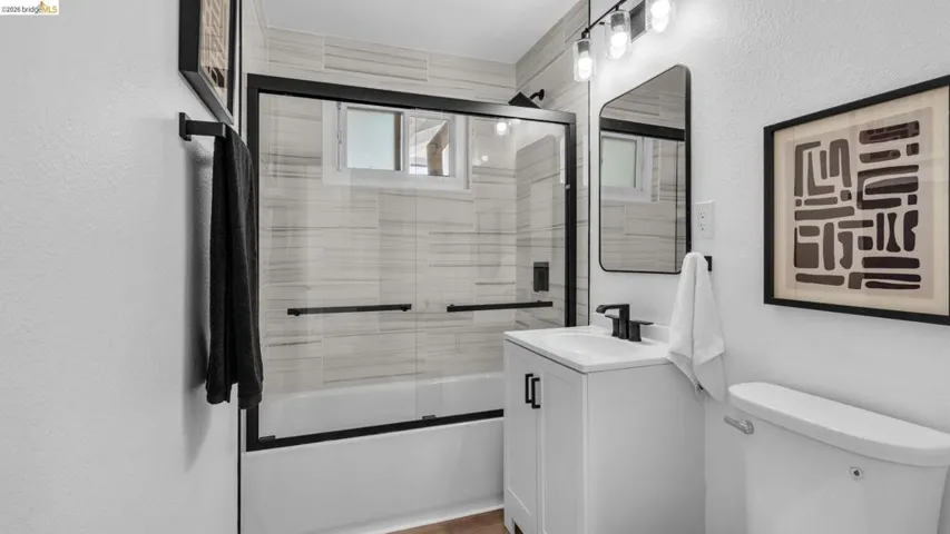 Contemporary bathroom featuring a white vanity with black hardware, a rectangular undermount sink, and a black single-handle faucet