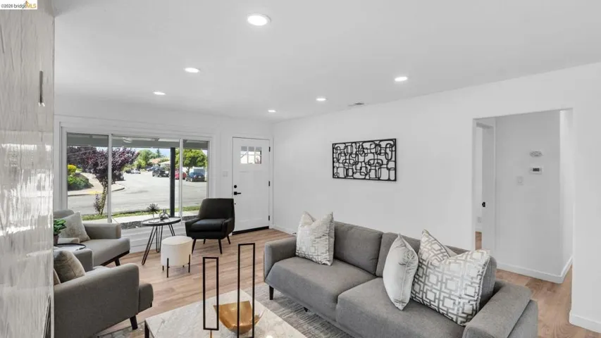 Open living area featuring wood-finish flooring, recessed lighting, and white walls