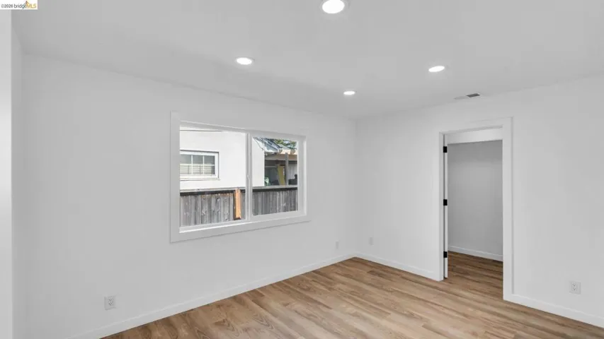 Bright interior space featuring wood-finish flooring, recessed lighting, and a white-trimmed window