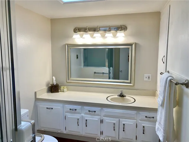 bathroom with modern vanity light fixture and skylight