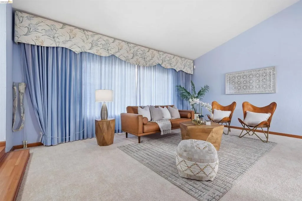 Expansive living area featuring a vaulted ceiling and wall-to-wall carpeting