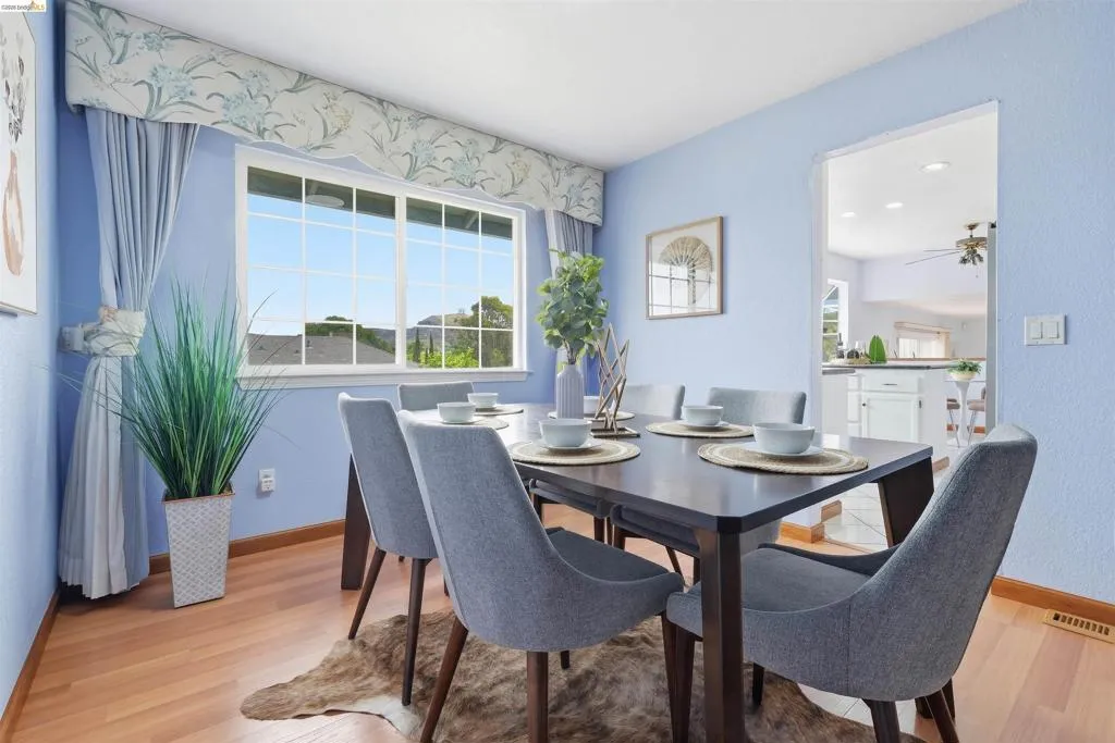 Dining area featuring light wood-finish flooring and a large window with white muntins