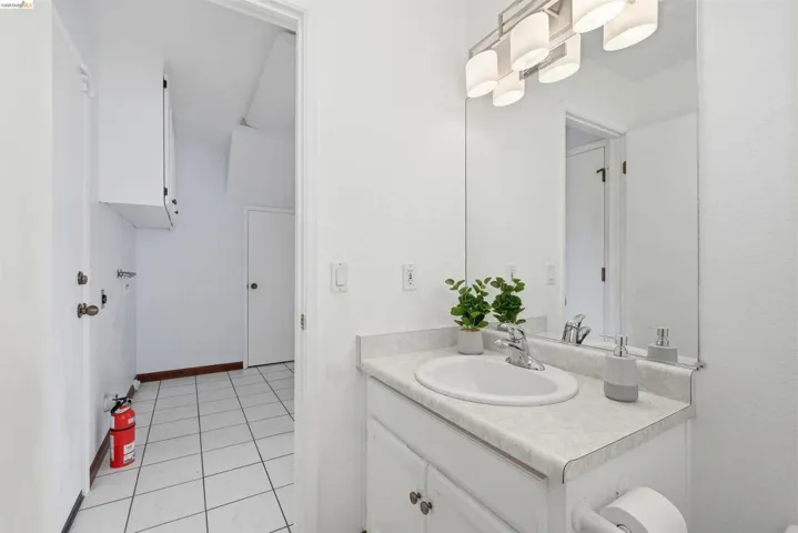 Bathroom vanity featuring an integrated sink, laminate countertop, and overhead light fixture