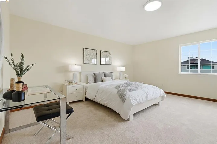 Bedroom featuring neutral-toned walls, recessed lighting, and a large window