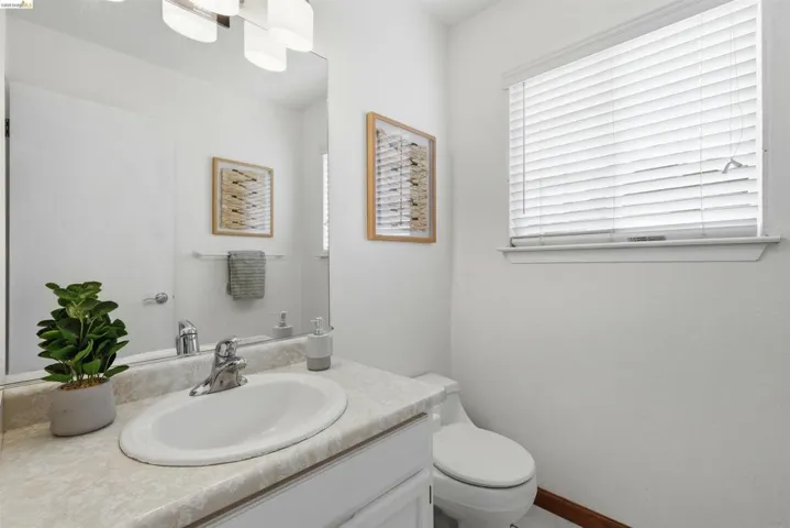 Bathroom featuring a white vanity with an integrated sink, polished chrome faucet, and a large wall-mounted mirror