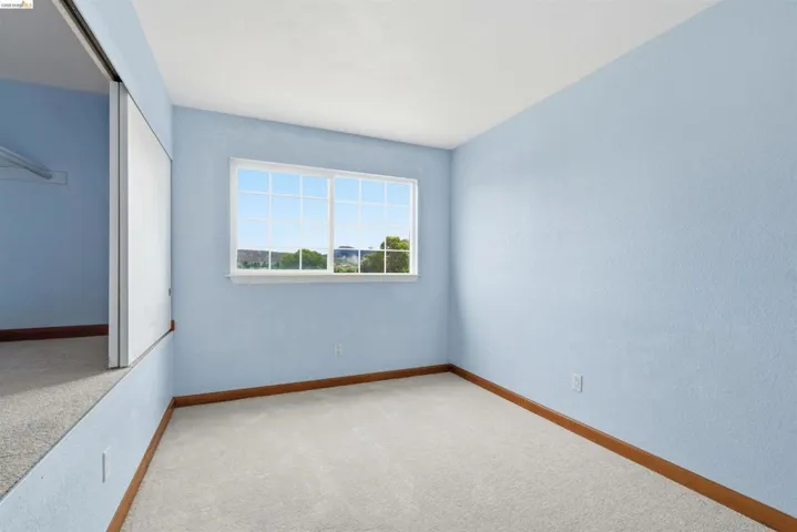 Carpeted room with a multi-pane window and light blue walls
