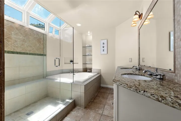 Light-filled master en-suite with dual vanities, a soaking tub, walk-in shower, and expansive natural light creating a spa-like retreat