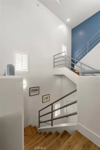 Architectural staircase view from the front entry rising through all levels to the third-story loft