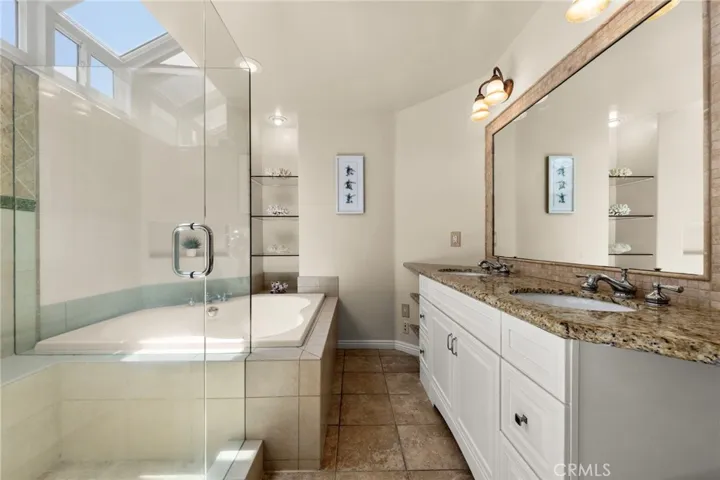 Spacious master en-suite featuring dual vanities with granite countertops, a soaking tub, walk-in shower, and an abundance of natural light