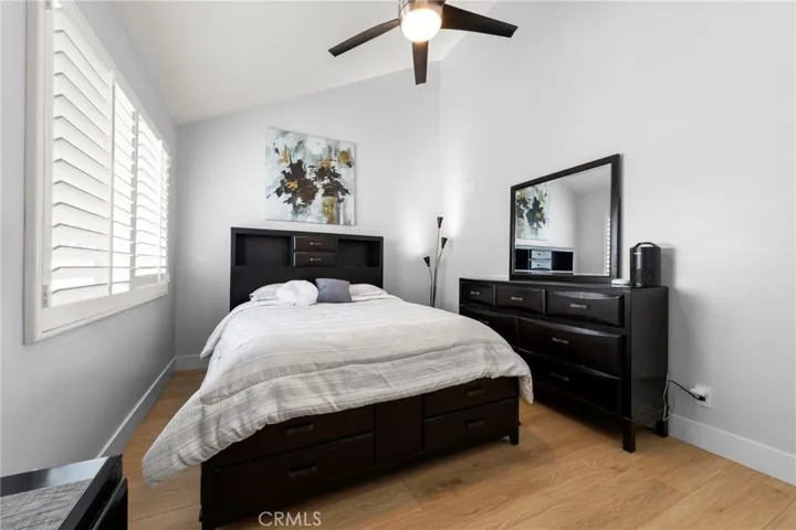 Spacious guest bedroom with vaulted ceilings, abundant natural light, and ceiling fan creating a bright and comfortable retreat