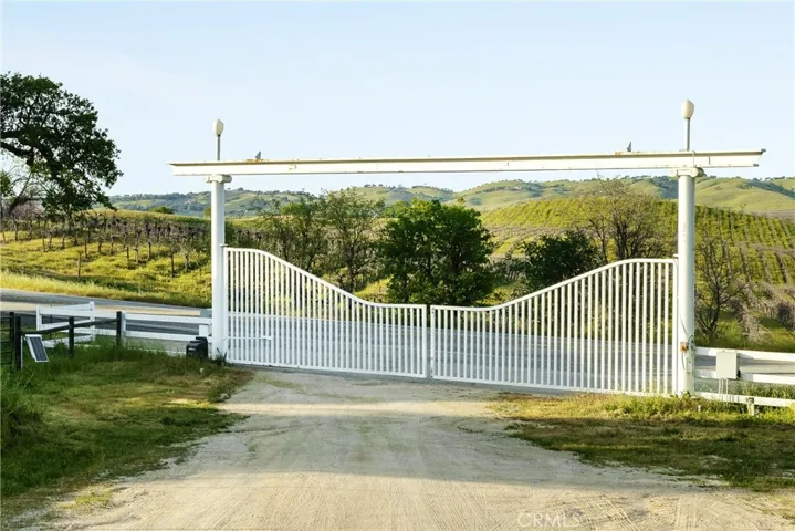View at driveway exit gate to 6685 El Pomar Drive, to the vineyards beyond