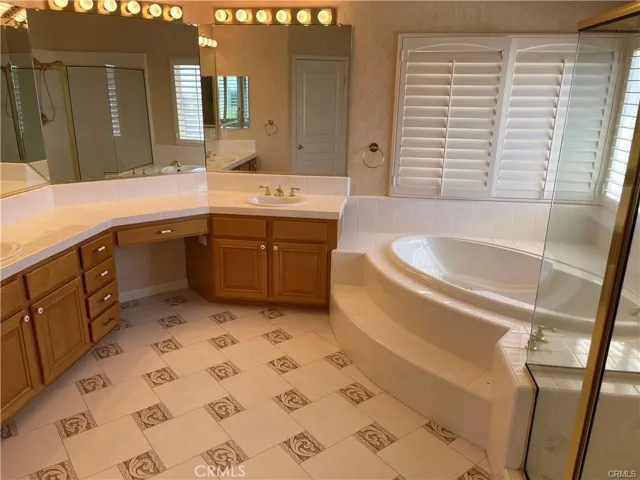 Master bathroom with sual sinks, soaking tub and stall shower