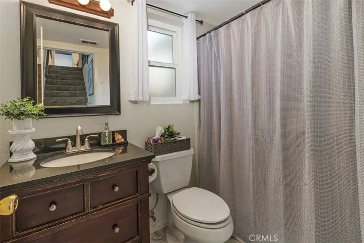 3/4 guest bath gives a peak-a-boo view of the pretty staircase.