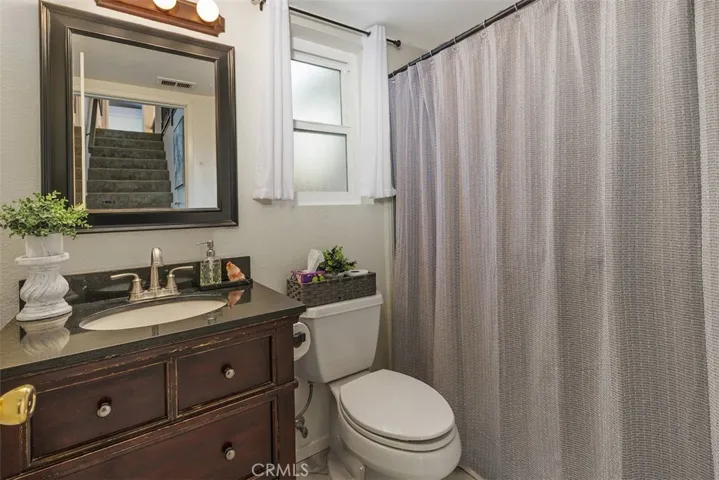 3/4 guest bath gives a peak-a-boo view of the pretty staircase.
