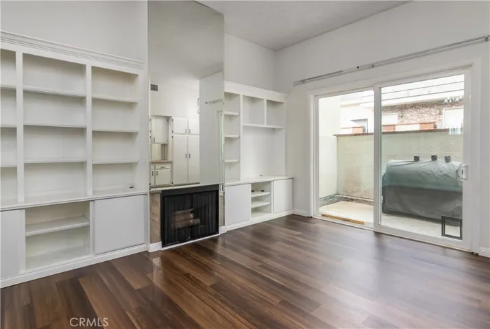 Another view of the living room, looking at the built in shelving and the fireplace.