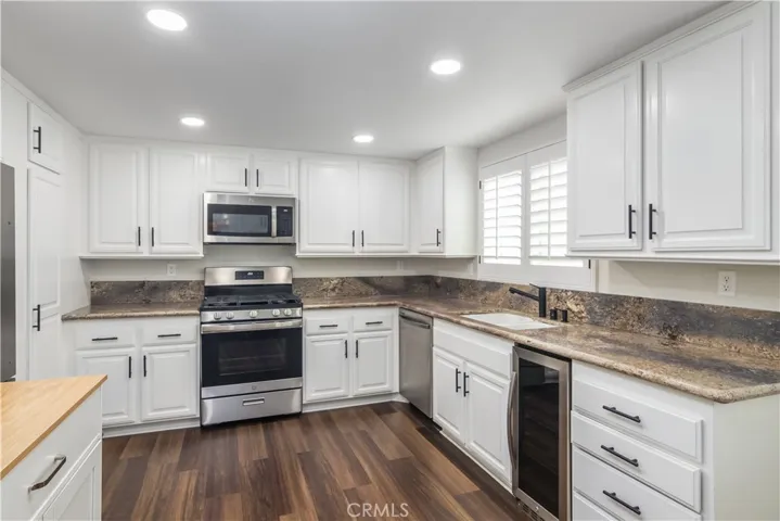 Kitchen with updated countertops, stainless steel appliences and recessed lights.
