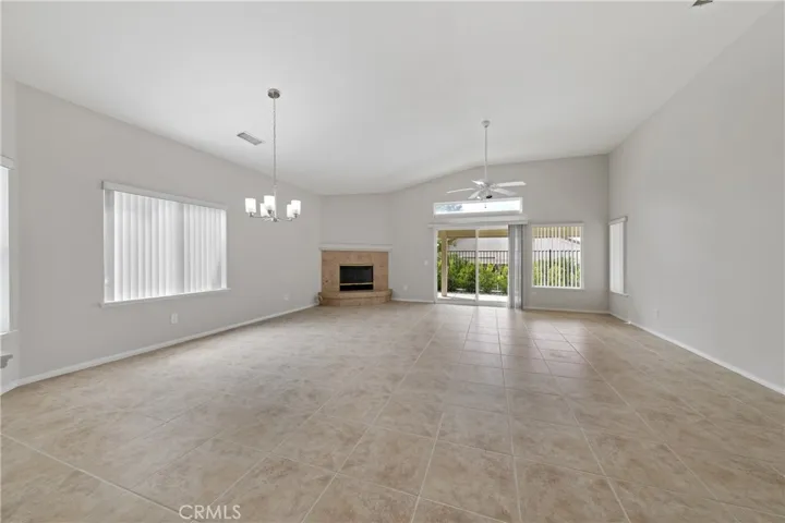 Great room for living and dining has tile flooring, a fireplace and opens to your patio.