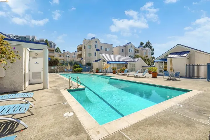 Community swimming pool featuring a rectangular design, concrete decking, and integrated entry steps