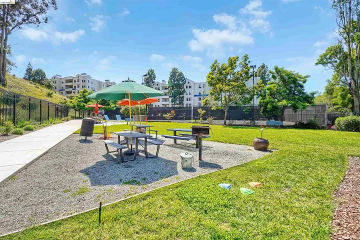 Outdoor recreation area featuring a gravel pad, two picnic tables, and two charcoal grills
