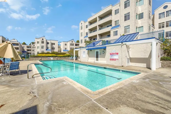 Outdoor swimming pool featuring a lap lane, concrete surround, and perimeter fencing