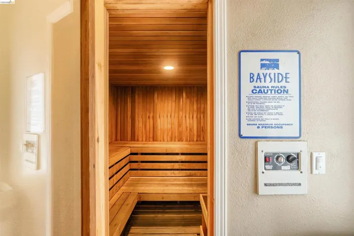 Wood-paneled sauna featuring built-in benches, recessed ceiling lighting, and wood-finish flooring