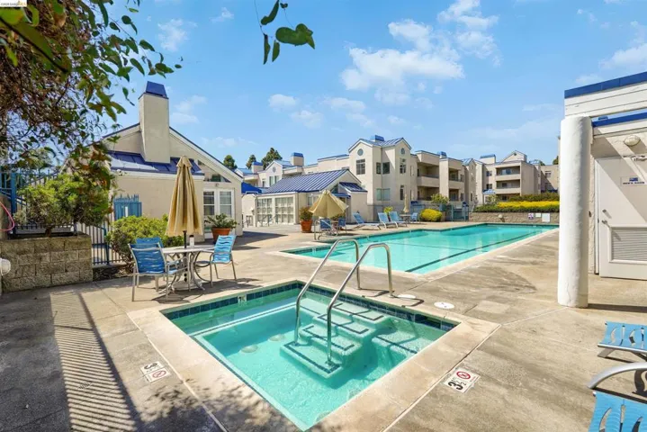 Outdoor concrete patio featuring a rectangular swimming pool and an integrated spa