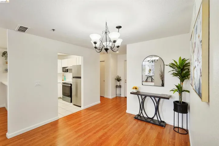 Bright interior space featuring wood-finish flooring and a contemporary chandelier