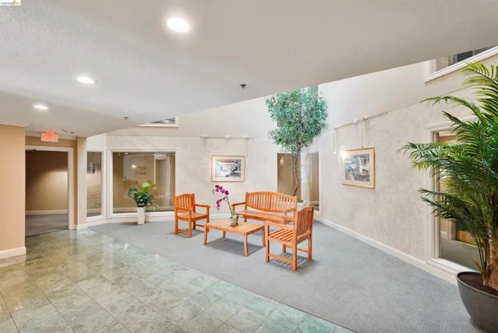 Building entryway featuring recessed lighting, a two-story atrium, and green-hued tile flooring