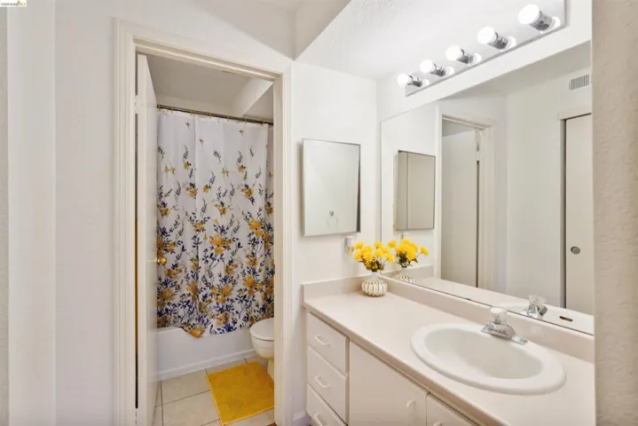 Bathroom vanity featuring an integrated sink, laminate countertop, and built-in cabinetry with drawer storage