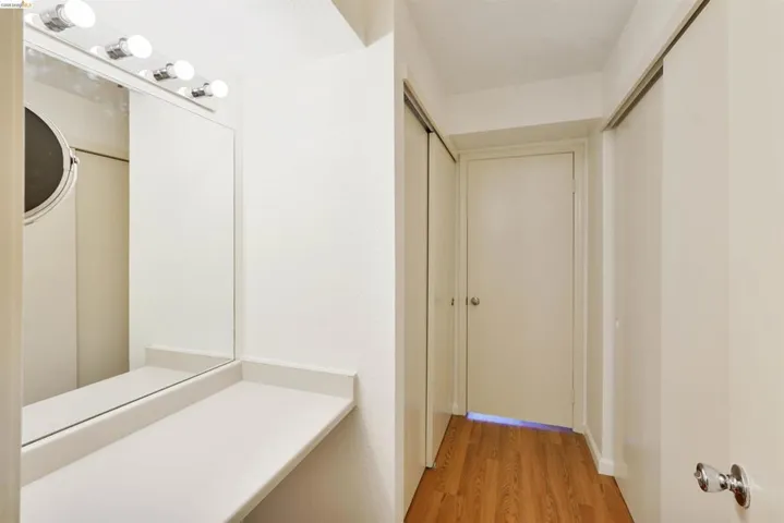 Vanity area featuring a built-in countertop, full-width mirror, and overhead strip lighting