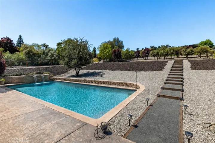 This image is AI created to show you what it would look like if you add a pool right off the patio where it's already flat and the driveway on the side to the back makes it easy access to have done.