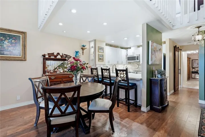 Dining area with kitchen, looking down hall towards main floor bedroom.