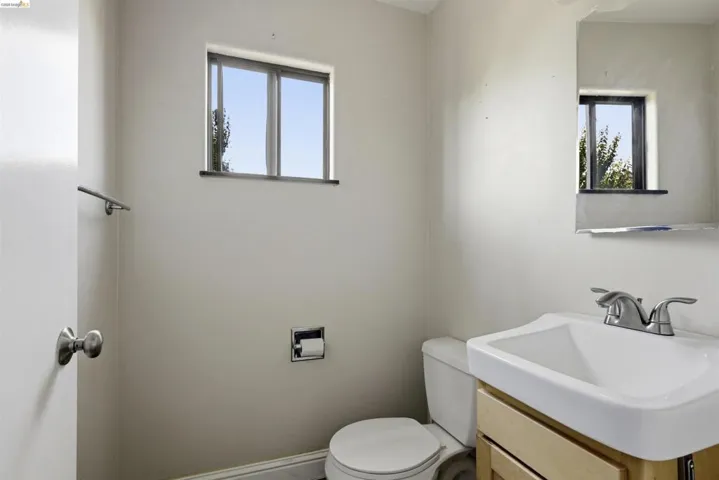 Bathroom featuring a single-pane window, vanity with a rectangular basin sink, and chrome fixtures