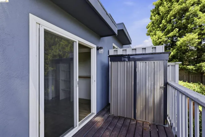 Outdoor balcony featuring wood decking and a sliding glass door
