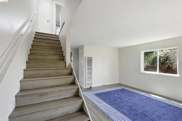 Hardwood-finish staircase featuring white risers and handrails