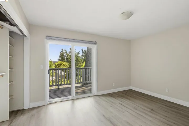Room featuring wood-finish flooring, light-toned walls, and a ceiling-mounted light fixture