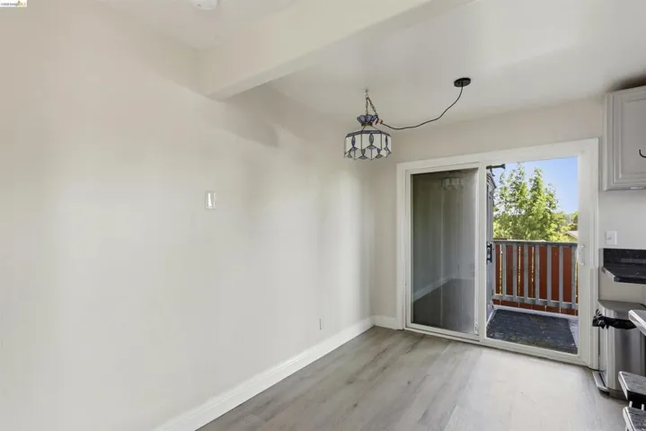 Dining area featuring wood-finish flooring and a sliding glass door opening to a private balcony with wood railing