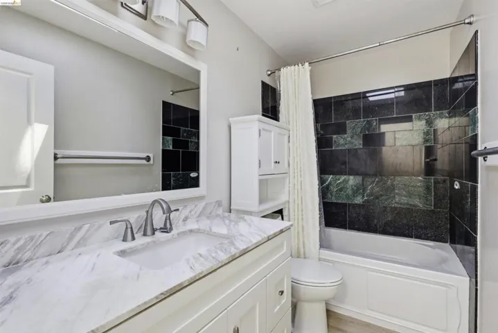 Bathroom vanity with a rectangular undermount sink, a gray veined countertop, and a brushed nickel widespread faucet