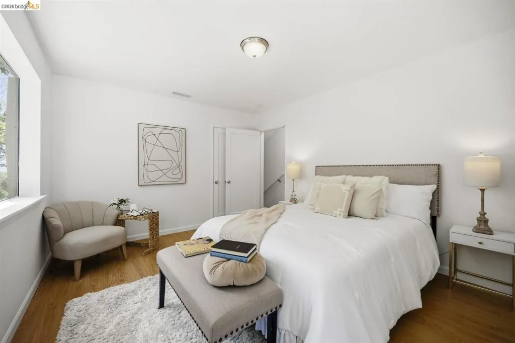 Light-filled room featuring wood-finish flooring and a window with white trim